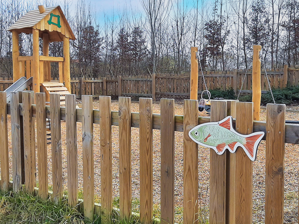 Signalétique pédagogique fabriquée en France. Représentation de poisson en Stratimage®, accroché sur une barrière. Installé dans un parc. signalétique pédagogique, panneau pédagogique, parcours, aire de jeux, sentier, espace vert, nature en ville